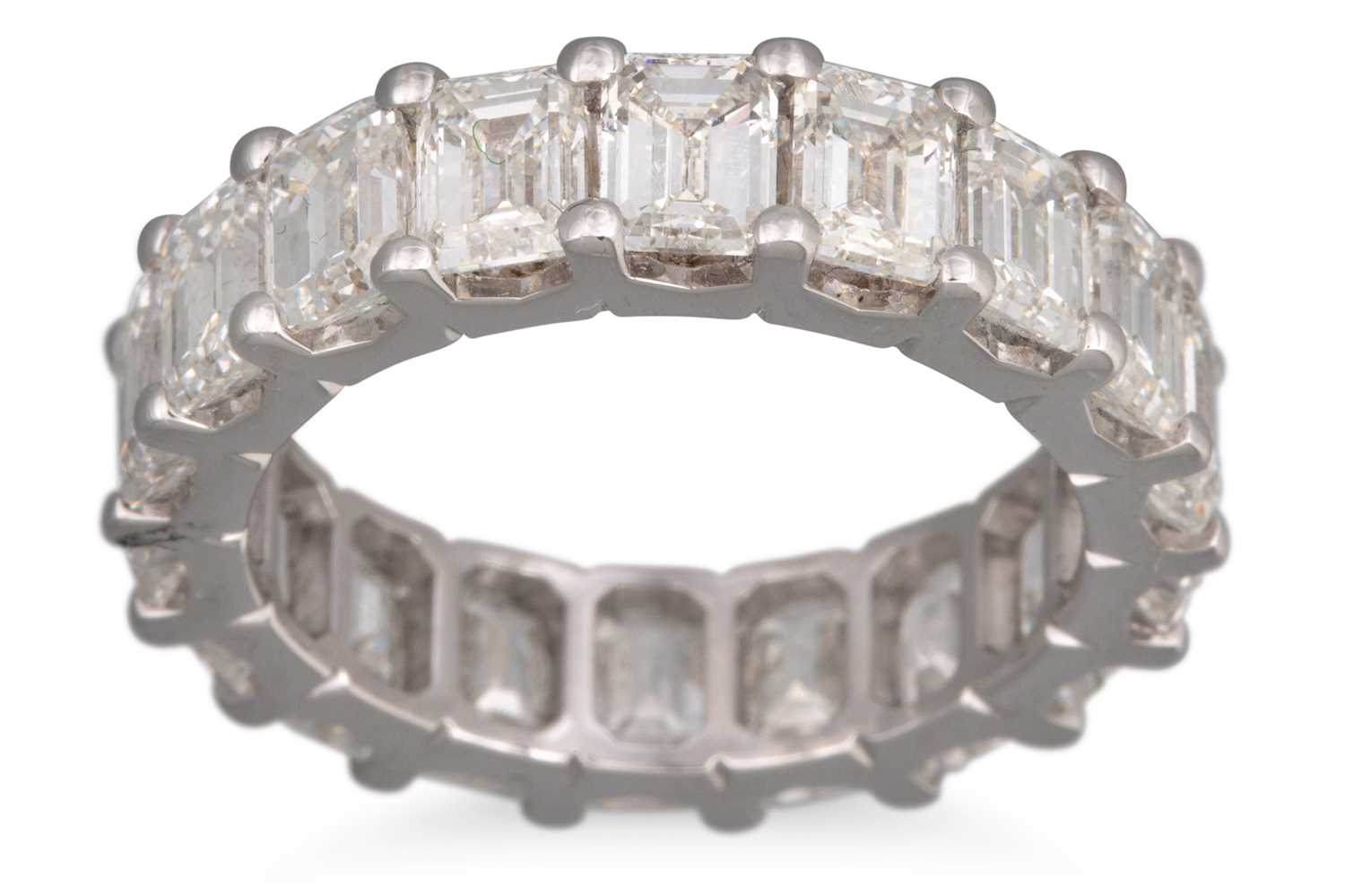 Lot 258 - AN EMERALD CUT FULL BANDED ETERNITY RING,...