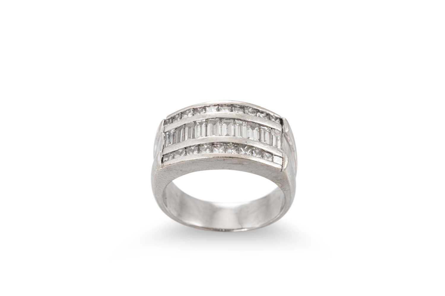 Lot 172 - A DIAMOND THREED ROWED RING, the channel set...