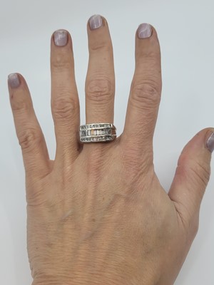 Lot 172 - A DIAMOND THREED ROWED RING, the channel set...