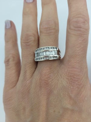 Lot 172 - A DIAMOND THREED ROWED RING, the channel set...