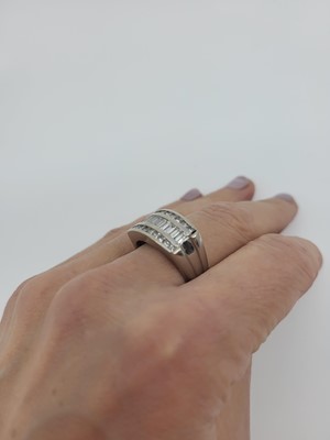 Lot 172 - A DIAMOND THREED ROWED RING, the channel set...