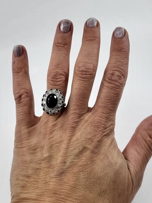 Lot 247 - A SAPPHIRE AND DIAMOND CLUSTER RING, the oval...