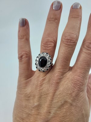 Lot 247 - A SAPPHIRE AND DIAMOND CLUSTER RING, the oval...