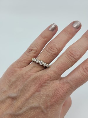 Lot 180 - A GRADUATED FIVE STONE DIAMOND RING, the round...