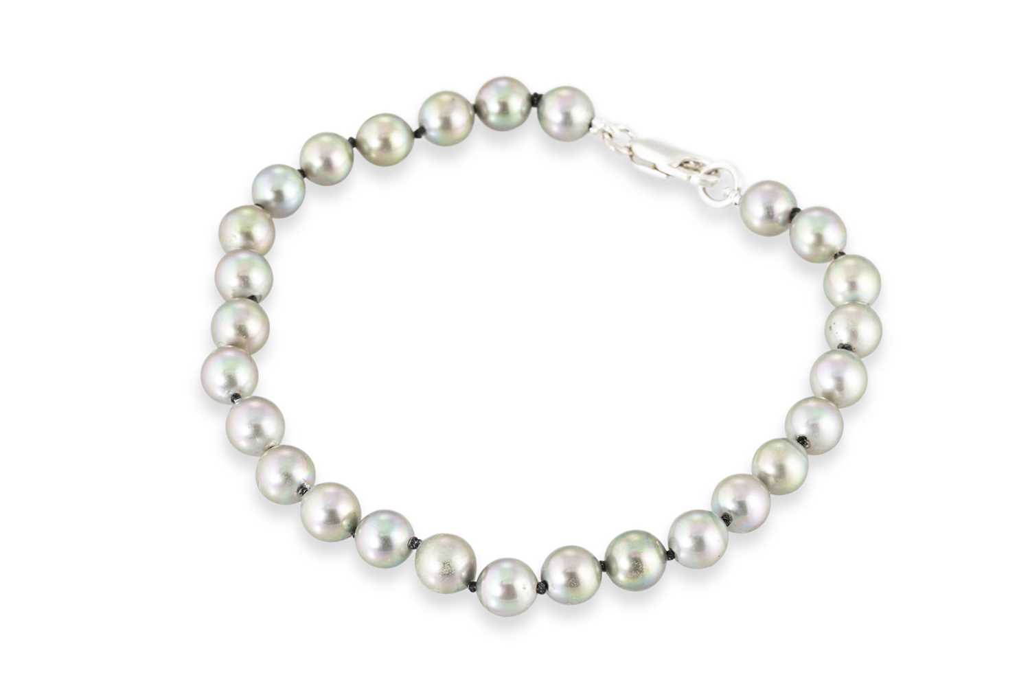 Lot 228 - A CULTURED PEARL BRACELET, grey with green...
