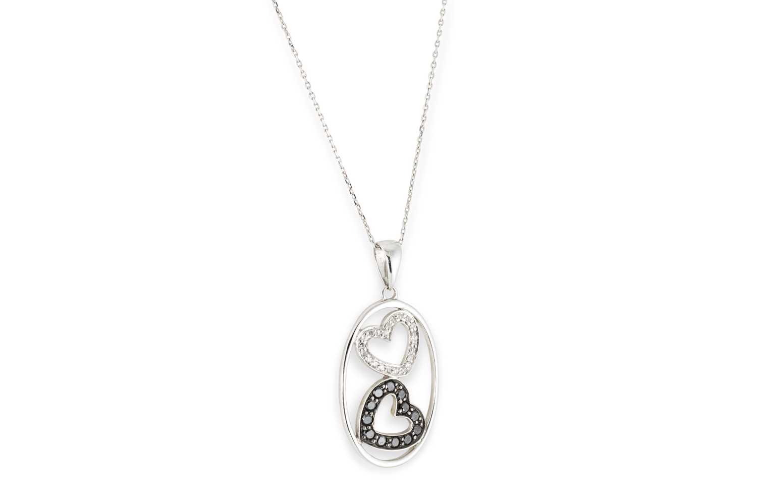 Lot 294 - A BLACK & WHITE DIAMOND LOVE HEART PENDANT, in...