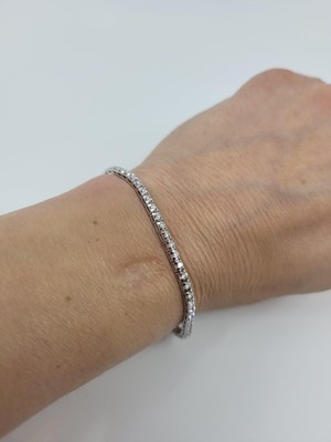 Lot 155 - A DIAMOND LINE BRACELET, the brilliant cut...