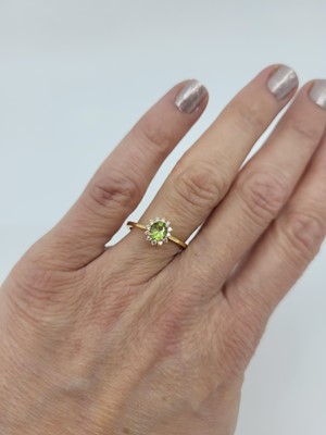 Lot 158 - A PERIDOT AND DIAMOND CLUSTER RING, mounted in...