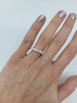 Lot 284 - A DIAMOND BAND RING, set with brilliant cut...