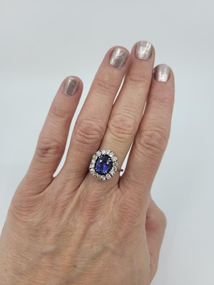 Lot 182 - A TANZANITE AND DIAMOND CLUSTER RING, the oval...