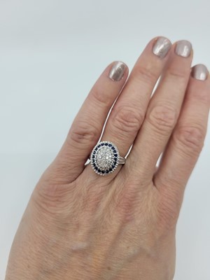 Lot 186 - A PAVÉ DIAMOND AND SAPPHIRE CLUSTER RING,...