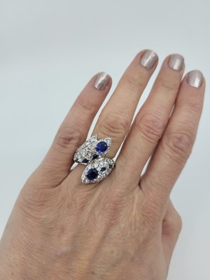 Lot 197 - A SAPPHIRE AND DIAMOND SET CROSS OVER CLUSTER...