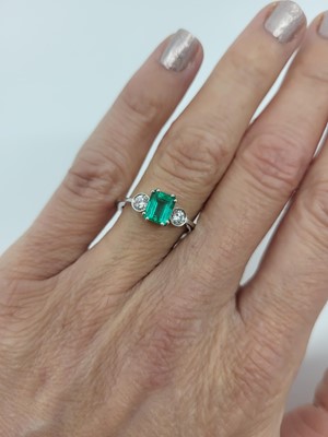 Lot 211 - AN EMERALD AND DIAMOND THREE STONE RING, the...