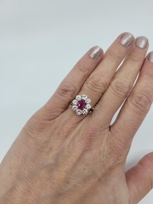 Lot 212 - A RUBY AND DIAMOND CLUSTER RING, the central...