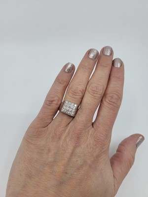 Lot 250 - A DIAMOND SET CLUSTER RING, the round...