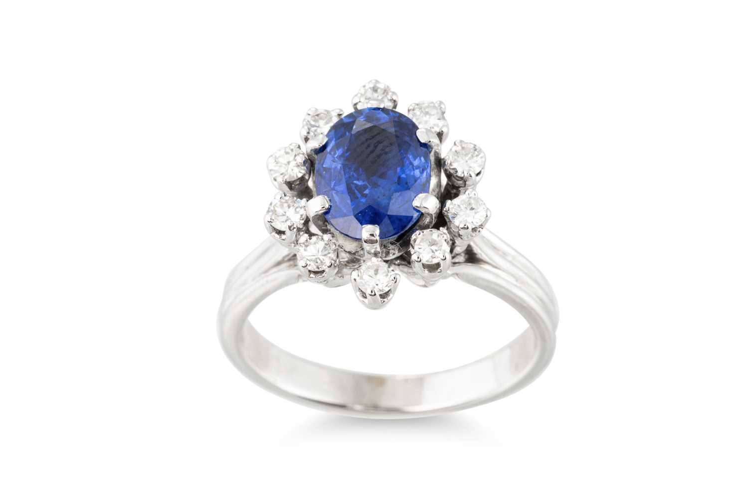 Lot 262 - A SAPPHIRE AND DIAMOND CLUSTER RING, the oval...
