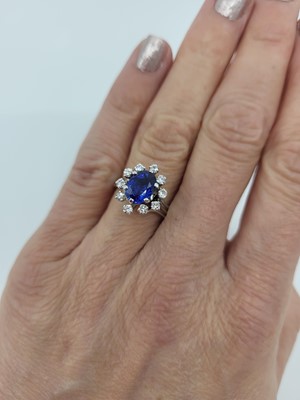 Lot 262 - A SAPPHIRE AND DIAMOND CLUSTER RING, the oval...