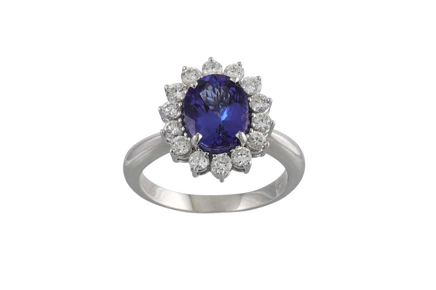 Lot 216 - A TANZANITE AND DIAMOND CLUSTER RING, the oval...