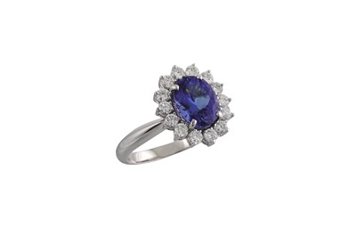 Lot 216 - A TANZANITE AND DIAMOND CLUSTER RING, the oval...