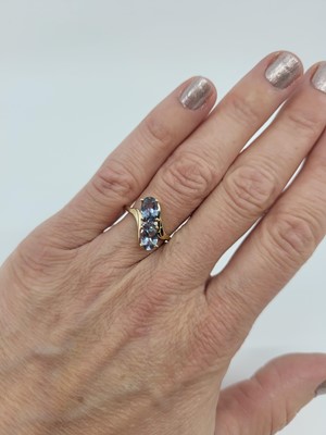 Lot 106 - A TOPAZ CLUSTER RING, of cross over style, the...