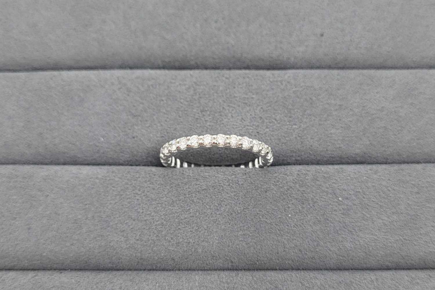 A DIAMOND SET FULL ETERNITY RING, the round...