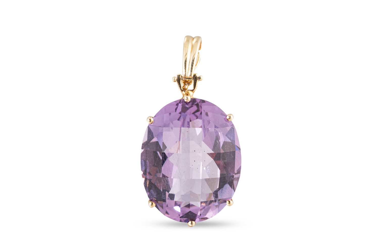 Lot 10 - AN AMETHYST SET PENDANT, the oval mixed cut...