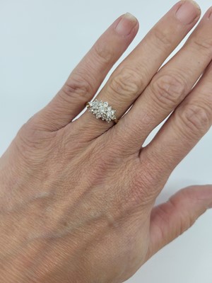Lot 116 - A DIAMOND SET CLUSTER RING, the round cut...