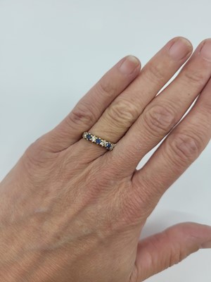 Lot 118 - A DIAMOND AND SAPPHIRE SEVEN STONE BAND RING,...