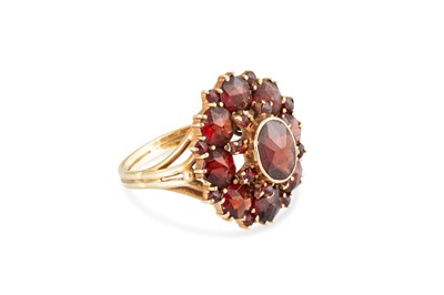 Lot 56 - A GARNET SET CLUSTER RING, the central oval...