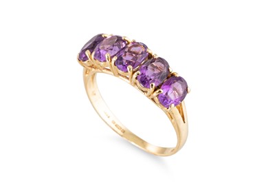 Lot 59 - AN AMETHYST FIVE STONE RING, the oval cut...