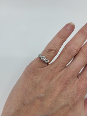 Lot 104 - A THREE STONE DIAMOND RING, the brilliant cut...