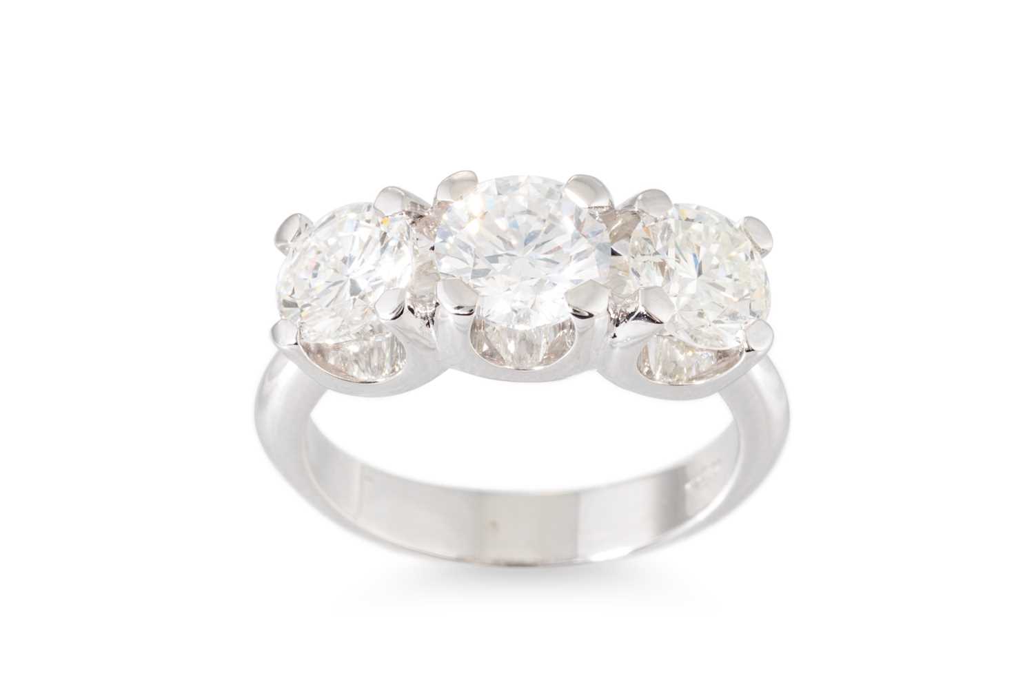Lot 322 - A DIAMOND THREE STONE RING, the brilliant cut...