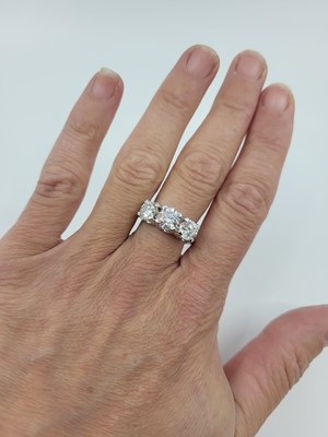 Lot 322 - A DIAMOND THREE STONE RING, the brilliant cut...