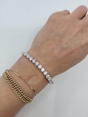 Lot 327 - A DIAMOND LINE BRACELET, the brilliant cut...