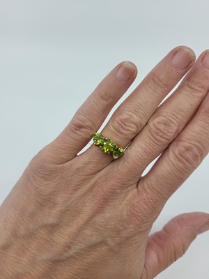 Lot 266 - A THREE STONE PERIDOT SET RING, mounted in 9ct...