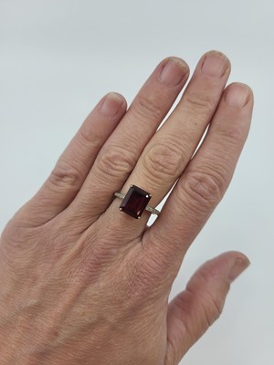 Lot 45 - A GARNET AND DIAMOND SET RING, the central...