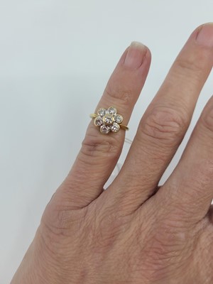 Lot 48 - A DIAMOND DAISY CLUSTER RING, the round...
