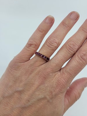 Lot 282 - A RUBY HALF ETERNITY RING, the baguette set...