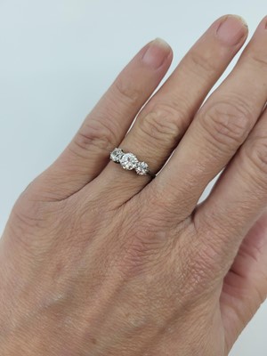 Lot 97 - A THREE STONE DIAMOND RING, the three round...