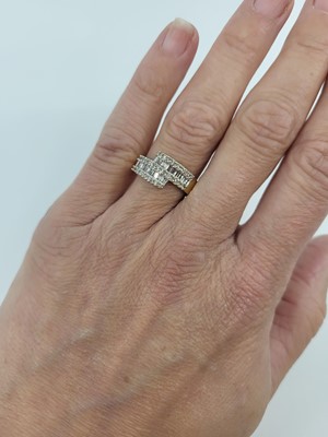 Lot 100 - A DIAMOND CLUSTER RING, the baguette and round...