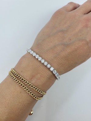 Lot 346 - A DIAMOND LINE BRACELET, the brilliant cut...