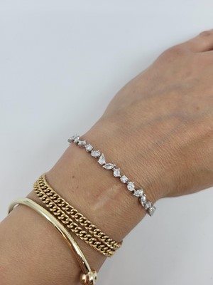 Lot 347 - A MIXED CUT DIAMOND LINE BRACELET, set with...