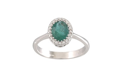 Lot 256 - AN EMERALD AND DIAMOND CLUSTER RING, oval form...