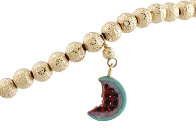 Lot 267 - A GOLD BEADED BRACELET, suspending enameled...
