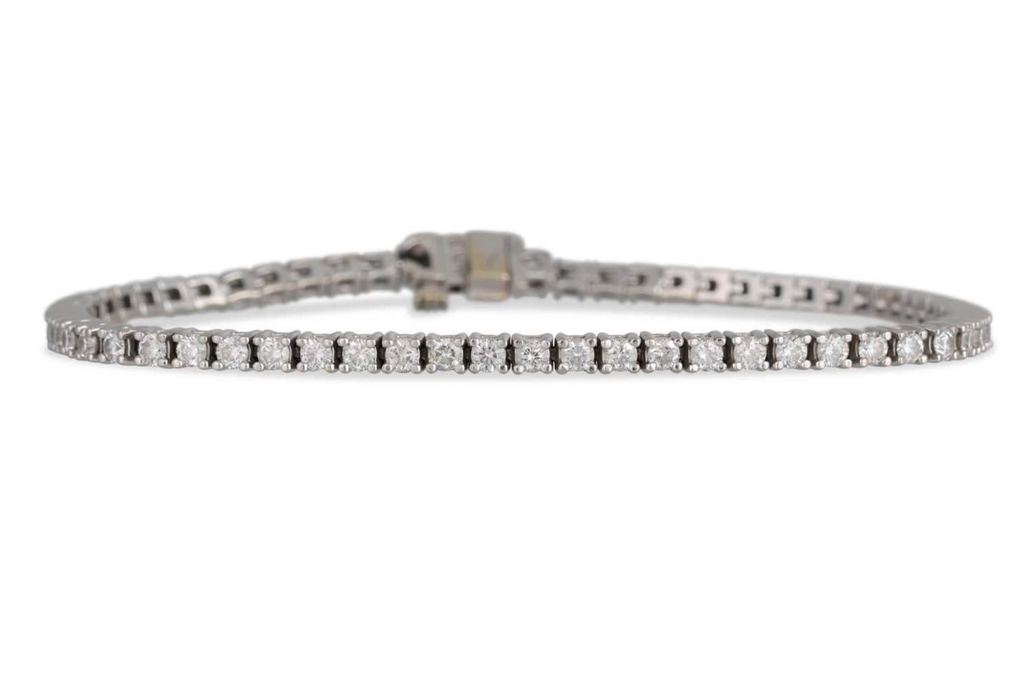Lot 56 - A DIAMOND LINE BRACELET, the brilliant cut...